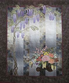 a quilted wall hanging with flowers on it