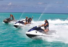 four people riding jet skis in the ocean