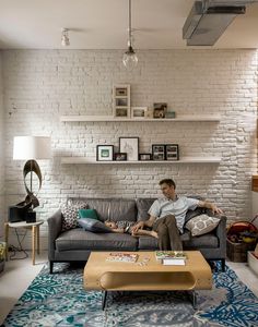 a man sitting on top of a couch in a living room