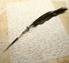 a feather quill sitting on top of a piece of paper