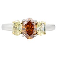 Finely crafted in platinum with a center GIA certified 1.12 carat Fancy Deep Brownish Yellowish Orange diamond. GIA certificate number: 2201779209 The ring features two yellow diamonds weighing approximately a total of 0.60 carats. Yellow Oval Brilliant Cut Diamond Ring, Yellow Diamond Platinum Ring With Center Stone, Yellow Diamond Cut Platinum Ring, Yellow Platinum Diamond Ring With Diamond Cut, Yellow Brilliant Cut Platinum Ring, Yellow Platinum Diamond Ring Fine Jewelry, Yellow Platinum Diamond Ring, Fine Jewelry Yellow Diamond Platinum Ring, Gia Certified Classic Yellow Diamond Ring