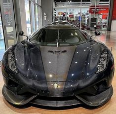 a black sports car is parked in a showroom