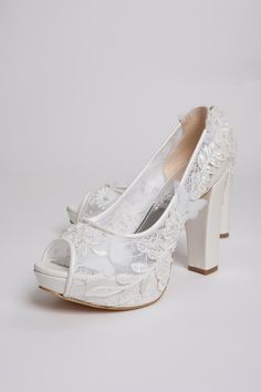 a pair of white wedding shoes with flowers on them