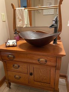 a bathroom sink sitting on top of a wooden dresser