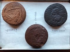 three chocolate cookies sitting on top of a piece of paper