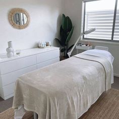 a white bed sitting next to a window in a bedroom