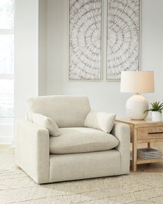 a living room with two paintings on the wall and a chair in front of it