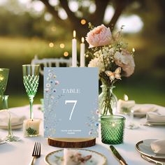 the table is set with candles, plates and glassware for an elegant wedding reception