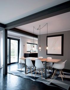 a dining room table with white chairs in front of a sliding glass door