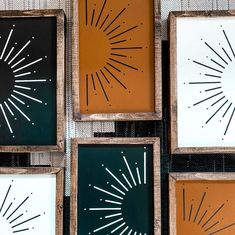 four framed art pieces with sunburst designs in them on a tablecloth covered surface