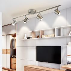 a tv is sitting on a shelf in the middle of a room with white walls and wooden flooring