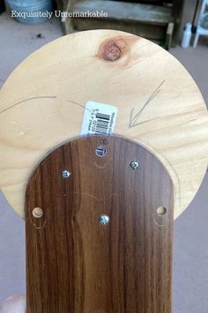 a close up of a person holding a piece of wood with metal rivets