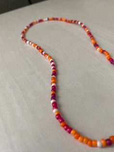 handmade beaded necklace in "sunset" 16-17 inches the necklace is elastic, and fits somewhat snug on most people (but it is not a choker) Orange Beaded Necklace For Summer, Casual Single Strand Beaded Necklace, Orange Beaded Necklaces With Colorful Round Beads, Summer Beaded Necklaces With Round Letter Beads, Minimalist Colorful Beaded Necklaces For Summer, Bohemian Orange Beaded Necklace With Letter Beads, Casual Orange Necklace With Round Beads, Casual Orange Beaded Necklaces, Adjustable Orange Beaded Necklaces With Tiny Beads