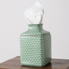 a tissue dispenser sitting on top of a wooden table