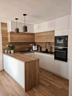 a kitchen with wooden floors and white cabinets