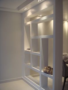 an empty room with white shelves and lighting