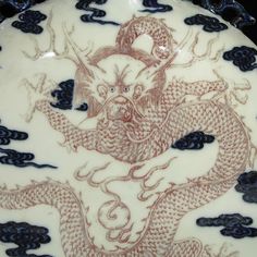 a white and blue vase with a dragon on it