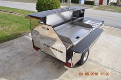 an outdoor kitchen trailer parked on the sidewalk