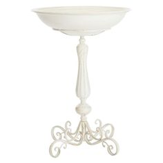 a white pedestal with an ornate design on the top and base, holding a bowl