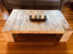 a wooden table with candles on it in front of a couch