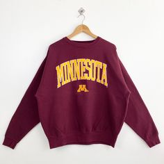 Vintage NCAA University of Minnesota 'Golden Gophers' Crewneck Sweatshirt Embroidery Logo Red Color Men's XL - Made in Pakistan - Materials : Cotton, Polyester  - Tag Reads : XL Kindly see the actual measurements (All measurements were taken lying flat) - Actual size manual measurements * Width (Armpit to armpit) : 26 inches * Length (Shoulder to end of garment) : 27 inches * Sleeve length : 25.5 inches - Condition : * Good condition 8/10 (80%) * Minor stain refer picture * Free from tear and major defect - Shipping : * DHL Express/FedEx Express = 3-6 business day arrived * Please PROVIDE your PHONE/CONTACT NUMBER for SHIPPING/DELIVERY purpose DON'T FORGET TO VISIT MY SHOP FOR MORE GREAT STUFF, THANK YOU. Red College Sweatshirt With Embroidered Logo, Red Embroidered Logo Top For College, Red Collegiate Tops With Embroidered Logo, College Red Tops With Embroidered Text, Red College Top With Embroidered Text, Red College Tops With Embroidered Text, Red Embroidered Text College Tops, Collegiate Embroidered Tops For College, Vintage College Sweatshirt With Embroidered Text