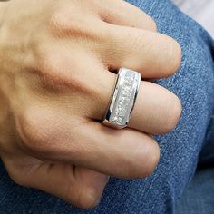 a man's hand wearing a silver ring with diamonds on the inside of it