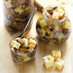 two jars filled with food sitting on top of a wooden table