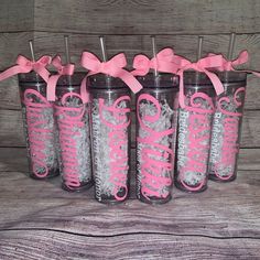 six pink and silver tumbles with bows on them