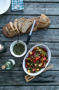 a table with bread, salad and wine on it