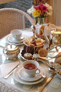 a table topped with plates and cups filled with food