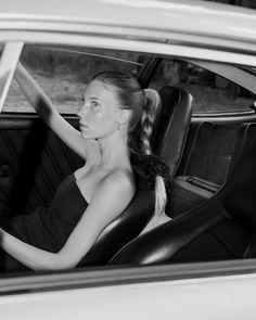 a woman sitting in the driver's seat of a car