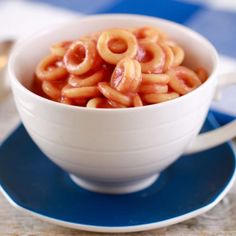 a white bowl filled with pasta sitting on top of a blue and white saucer