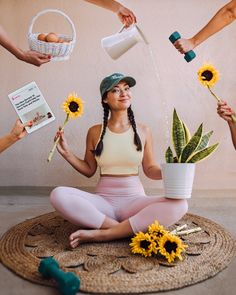 a woman sitting on the floor with sunflowers in front of her and other people holding