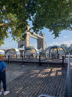 people are standing in front of the glass domes that look like they're floating on water