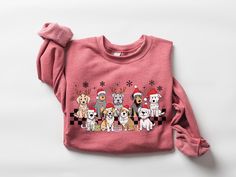 a pink sweater with dogs wearing santa hats on it's chest and the words merry christmas written across the front