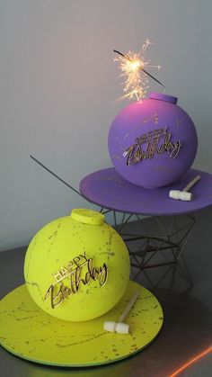 two birthday balloons with sparklers on them sitting on top of each other in front of a white wall