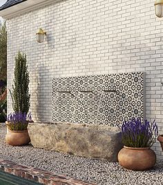 three potted plants sitting on the side of a building next to a swimming pool