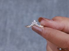 a woman's hand holding a diamond ring