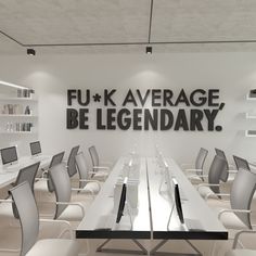 an empty conference room with white chairs and black letters on the wall that says fu - k average, be legendary