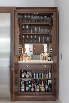 a wooden cabinet filled with lots of bottles and glasses