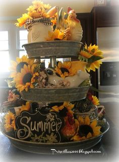 a tiered cake decorated with sunflowers and other decorations