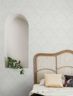 a bed with pillows and a pillow on top of it next to a wall mounted mirror