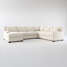 a white sectional couch sitting on top of a white floor