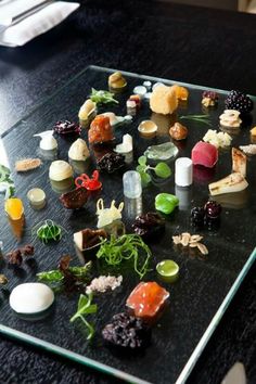 a table topped with lots of different types of food on top of a glass tray