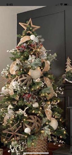 a christmas tree decorated with gold and white ribbons, star ornaments and other holiday decorations