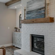 a white brick fireplace with a painting on the mantle