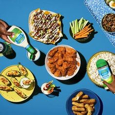 a table topped with lots of different types of food next to bottles of beer and plates of food