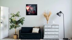 a living room with a couch, chair and painting hanging on the wall above it