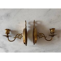 two brass wall sconces, one with three lights and the other has a candle holder