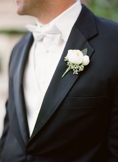 a man in a tuxedo with a boutonniere on his lapel